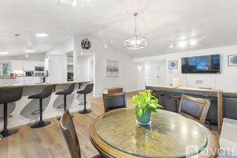 A modern dining room with a glass table and chairs.