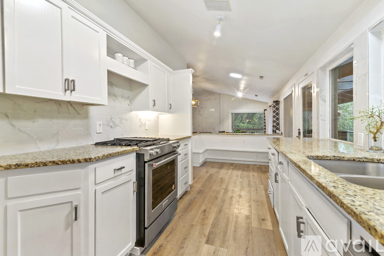 A kitchen with white cabinets and a granite countertop.