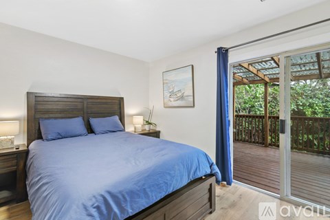 A bedroom with a large bed and a balcony.
