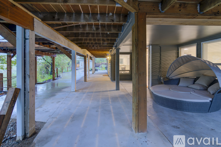 A large open space with a bed and a wooden beam ceiling.
