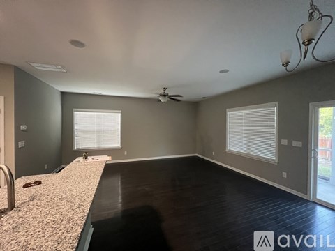 A spacious room with a long counter and a ceiling fan.