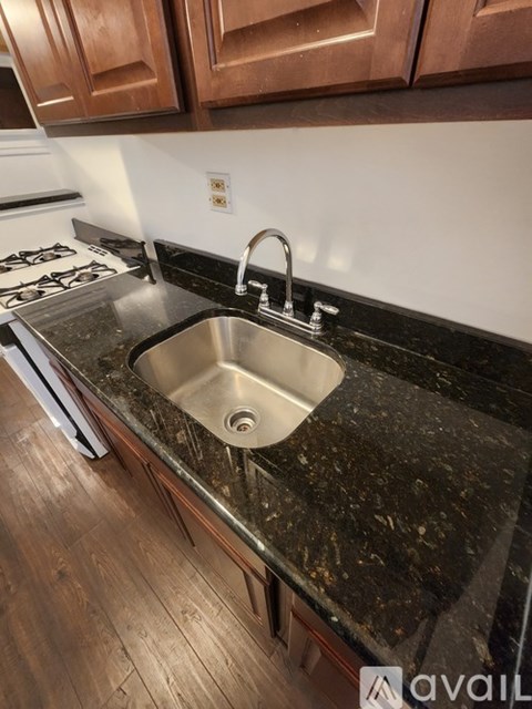 A kitchen with a sink and wooden cabinets.