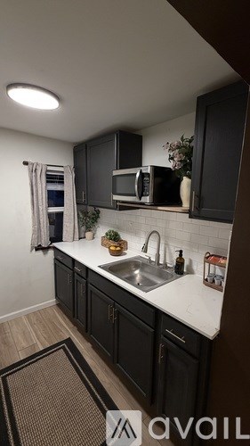 A kitchen with black cabinets and a white countertop.