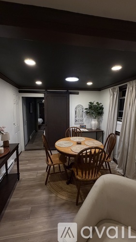 A dining room with a round table and chairs.