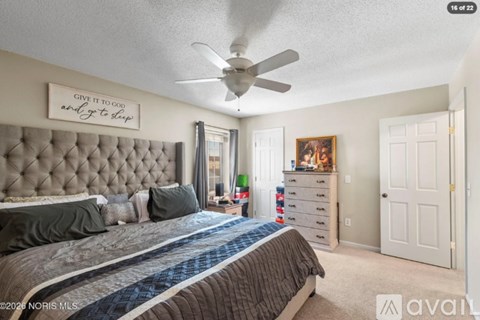 A bedroom with a large bed and a dresser with a mirror.