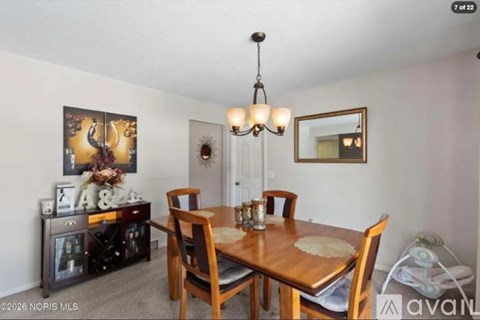 A dining room with a wooden table and chairs.