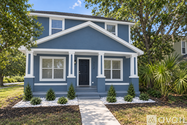 A blue house with white trim and a black front door.