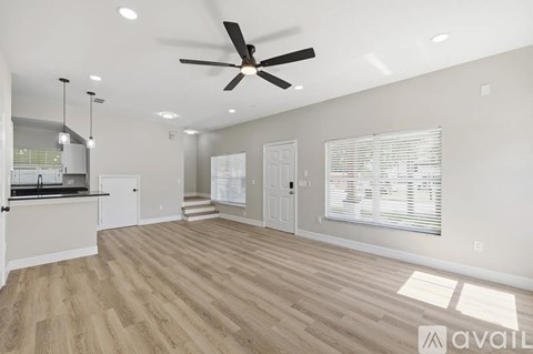A spacious room with a ceiling fan and lighting fixtures.