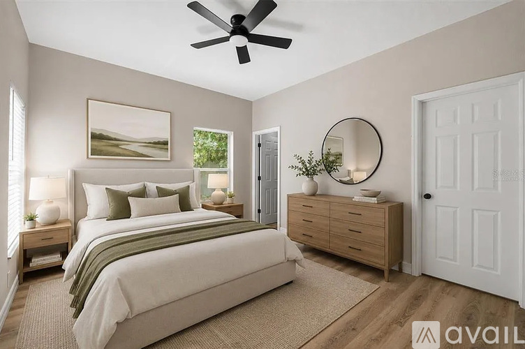 A bedroom with a large bed, a dresser, and a ceiling fan.