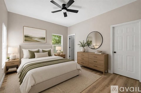 A bedroom with a large bed, a dresser, and a ceiling fan.