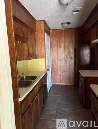 A kitchen with wooden cabinets and a sink.