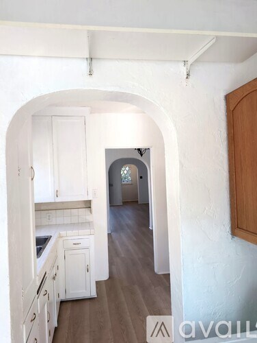 A kitchen with white cabinets and a wooden door.