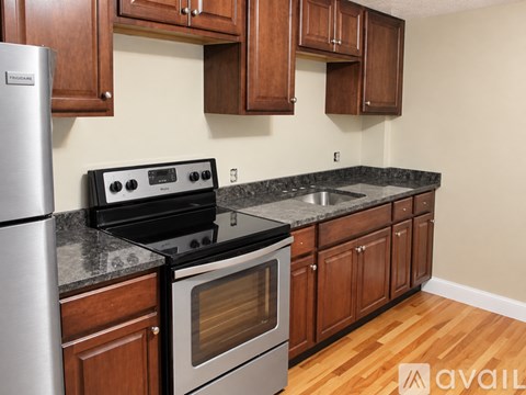 A kitchen with wooden cabinets and a stainless steel refrigerator.
