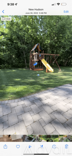 A playground with a yellow slide and a wooden structure.