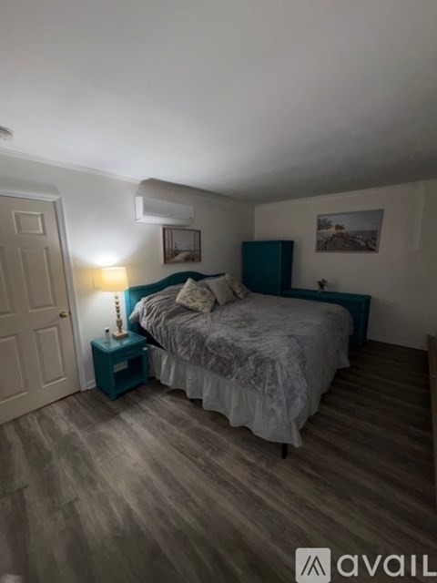 A bedroom with a bed, nightstand, and lamp.