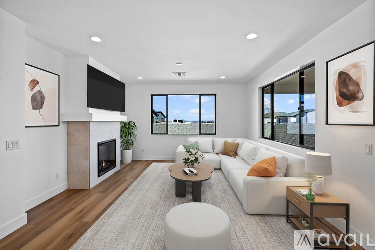 A modern living room with a white sofa, a grey rug, and a fireplace.