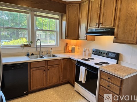A kitchen with wooden cabinets and a black stove top oven.