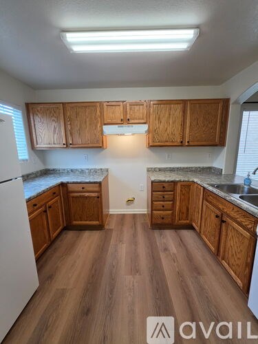 A kitchen with wooden cabinets and a white refrigerator.