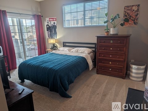 A bedroom with a bed, nightstand, and a dresser.