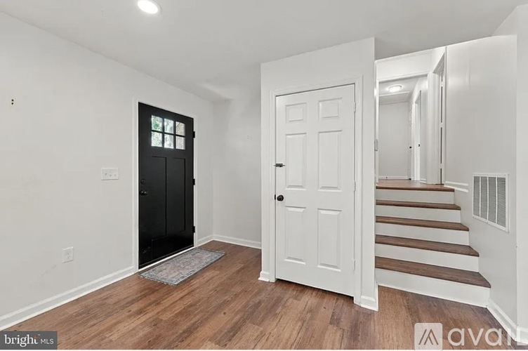 A hallway with a black door and a white door.