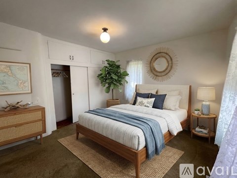 A bedroom with a large bed and a plant on the side table.