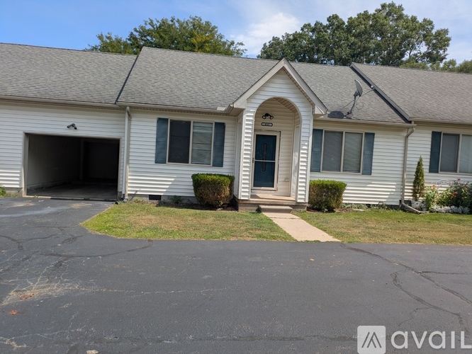 A house with a garage and a driveway in front.