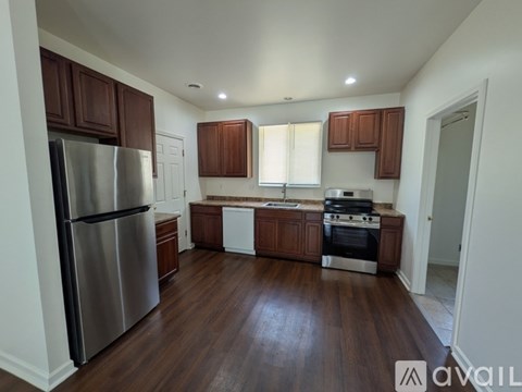 A kitchen with wooden cabinets and a stainless steel refrigerator.