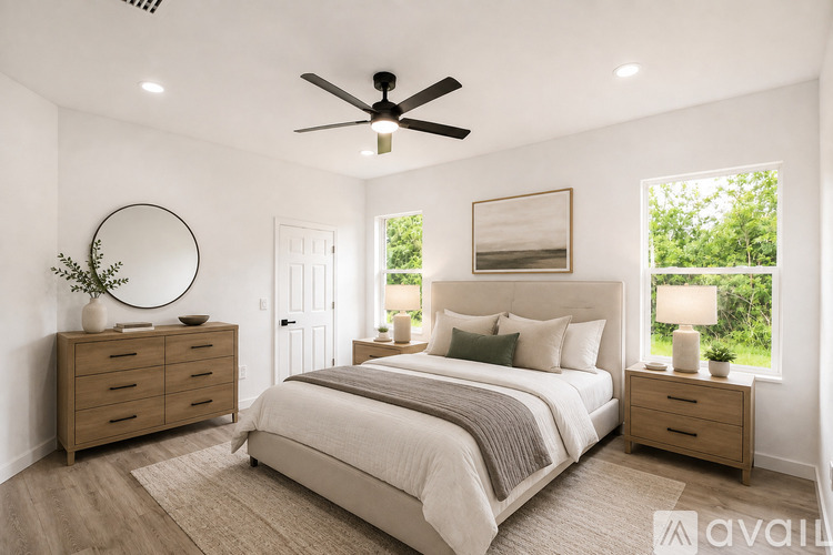 A bedroom with a large bed, a dresser, and a ceiling fan.