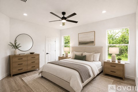 A bedroom with a large bed, a dresser, and a ceiling fan.