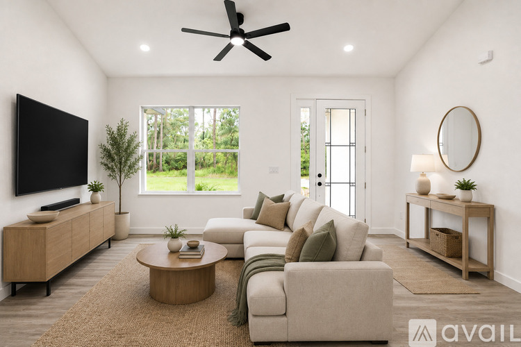 A living room with a large couch, a television, and a ceiling fan.
