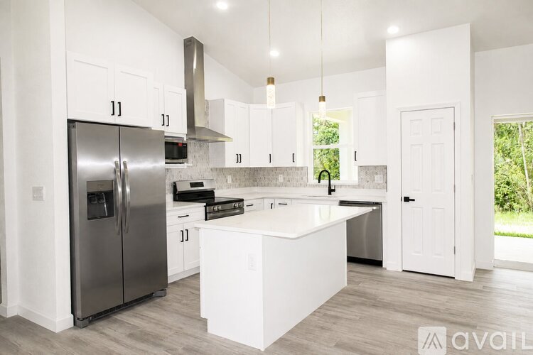 A modern kitchen with white cabinets and a central island.