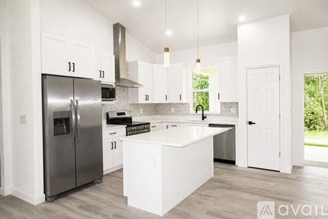 A modern kitchen with white cabinets and a central island.