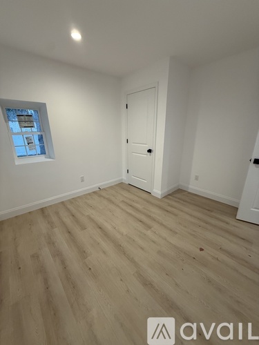 A room with wooden flooring and a white door.