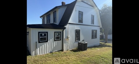 A white house with a black roof and a window with a black frame.