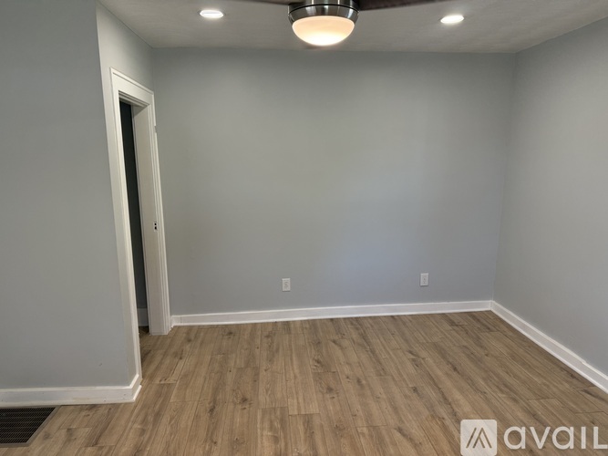 A room with wooden flooring and a ceiling light fixture.