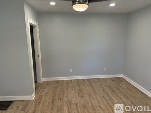 A room with wooden flooring and a ceiling light fixture.