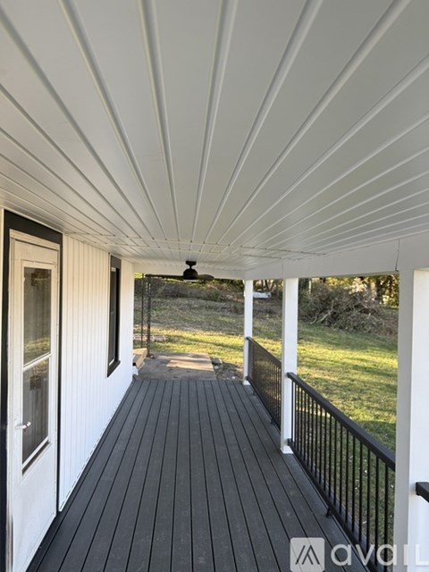 A white deck with a black railing and a ceiling fan.