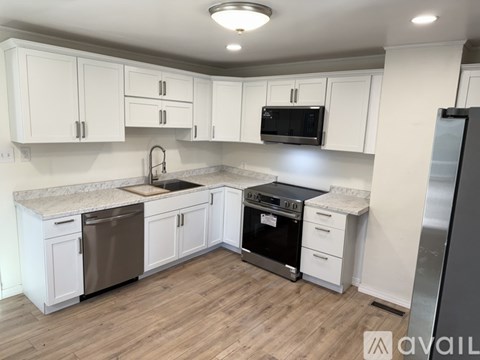 A kitchen with white cabinets and a black stove top oven.
