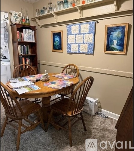 A dining room with a wooden table and chairs.