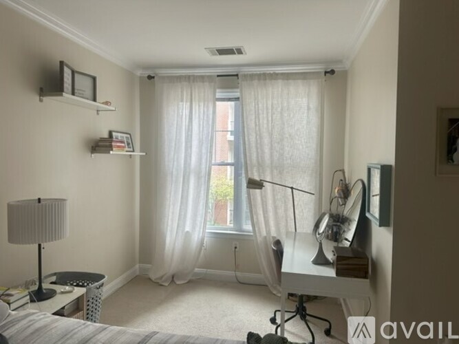 A bedroom with a bed, desk, and chair.