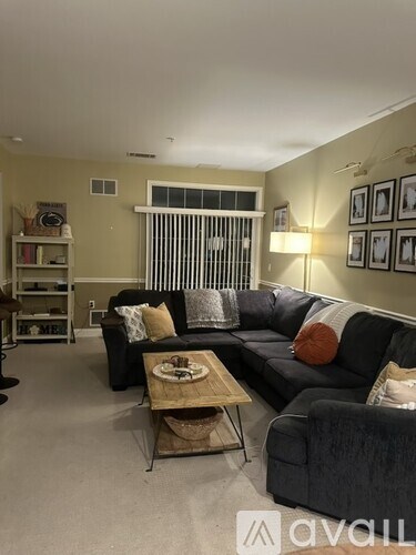 A living room with a black couch and a coffee table.