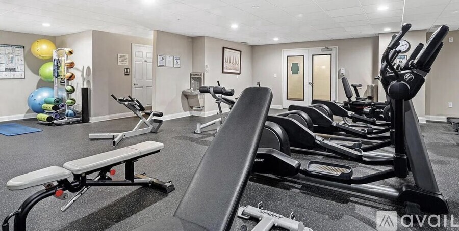 A well-equipped gym with various exercise machines and a bench.