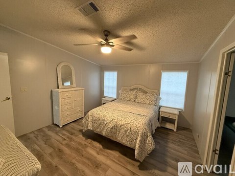 A bedroom with a bed, dresser, and mirror.