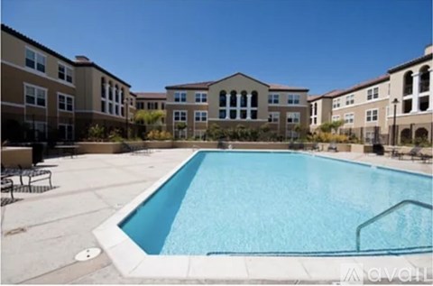 A large swimming pool in front of apartment buildings.