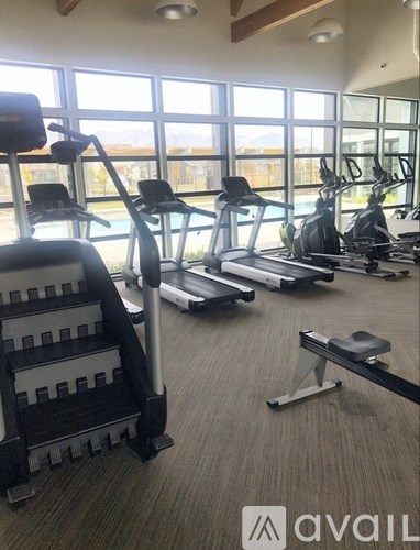 A gym with treadmills, elliptical machines, and a weight bench.