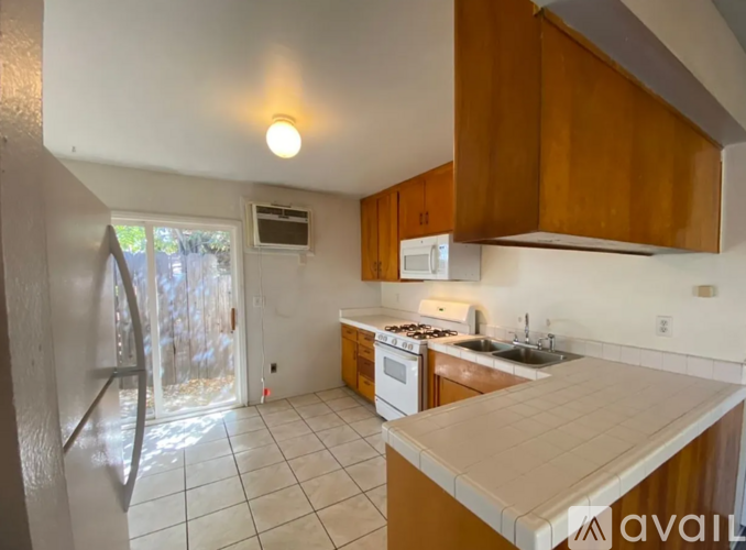 A kitchen with a white counter top and wooden cabinets.