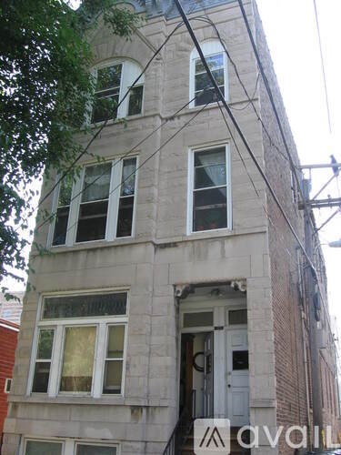 A tall building with a balcony on the second floor from the front.