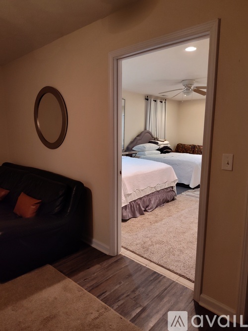 A bedroom with a bed, a couch, and a ceiling fan.