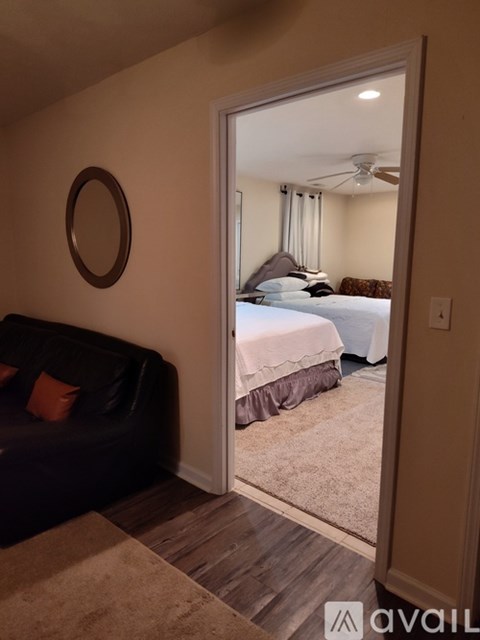 A bedroom with a bed, a couch, and a ceiling fan.