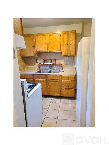 A kitchen with wooden cabinets and a white refrigerator.